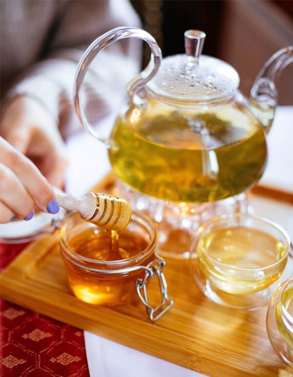 Slika prikazuje ajdov čaj z stekleničko medu za blog ajdov čaj