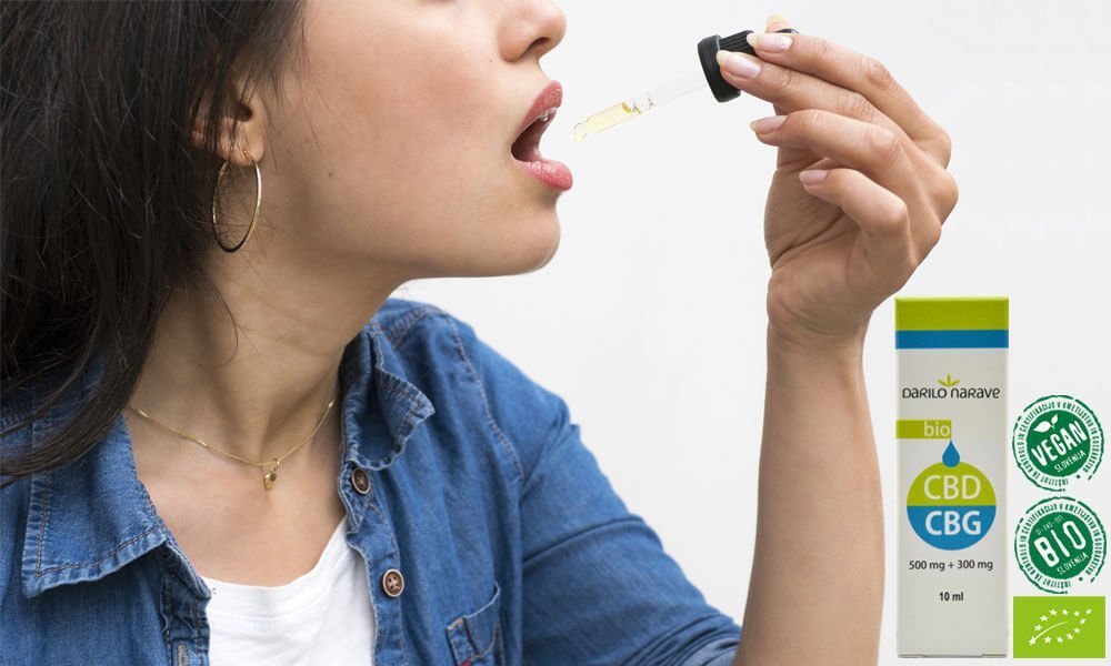 Na sliki vidimo lepo dekle, ki si daje kapljice CBD in CBG konopljinega olja v usta. Kakšno je delovanje CBD kapljic. Kako pravilno jemati zdravila in CBD kapljice?